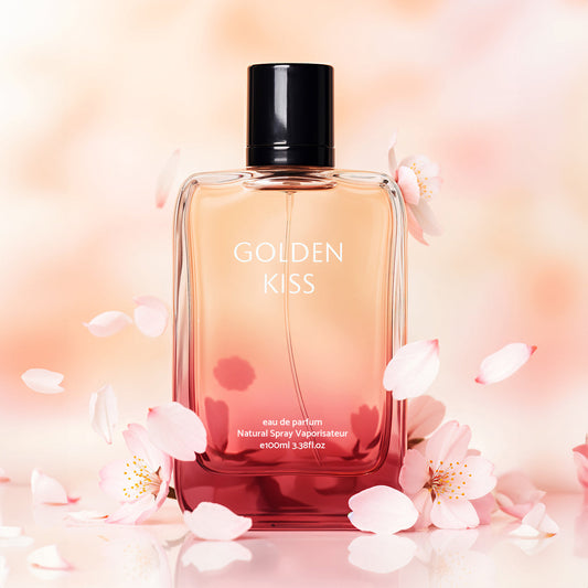 Perfume bottle labeled 'Golden Kiss' surrounded by cherry blossoms on a soft pink background